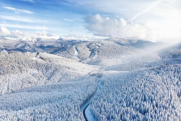 Vista aérea na estrada e floresta no inverno Paisagem natural de inverno do ar Floresta sob a neve no inverno Paisagem do drone