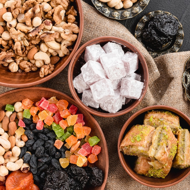 Una vista aérea de nueces mixtas; frutas secas; Lukum y baklava en cuenco de barro para ramadan