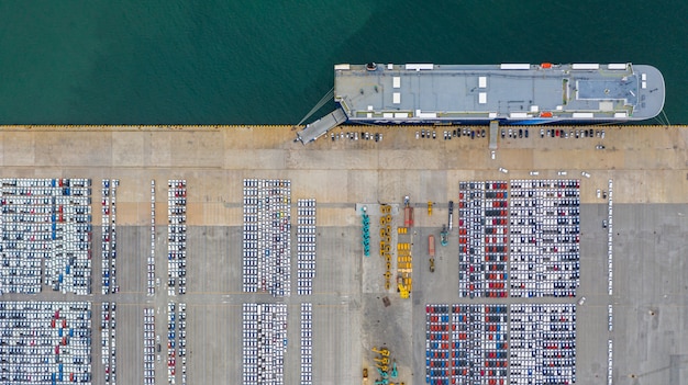 Vista aérea nueva terminal de exportación de automóviles, automóviles nuevos a la espera de importación y exportación en el puerto de aguas profundas.