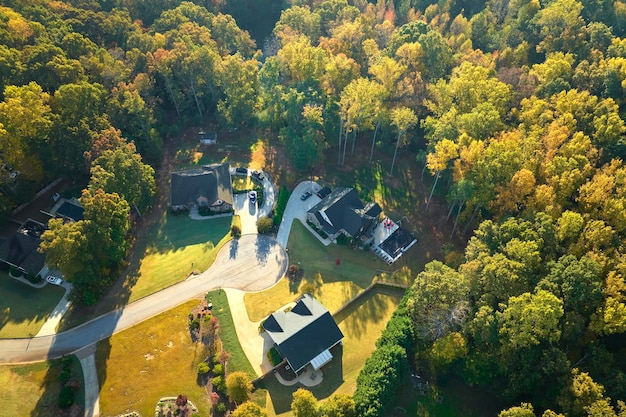 Vista aérea de nuevas casas familiares entre árboles amarillos en el área suburbana de Carolina del Sur en la temporada de otoño Desarrollo inmobiliario en los suburbios estadounidenses