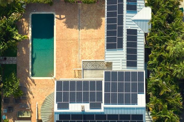 Vista aérea del nuevo y costoso techo de la casa estadounidense con paneles solares fotovoltaicos azules para producir energía eléctrica ecológica limpia Electricidad renovable con concepto de cero emisiones