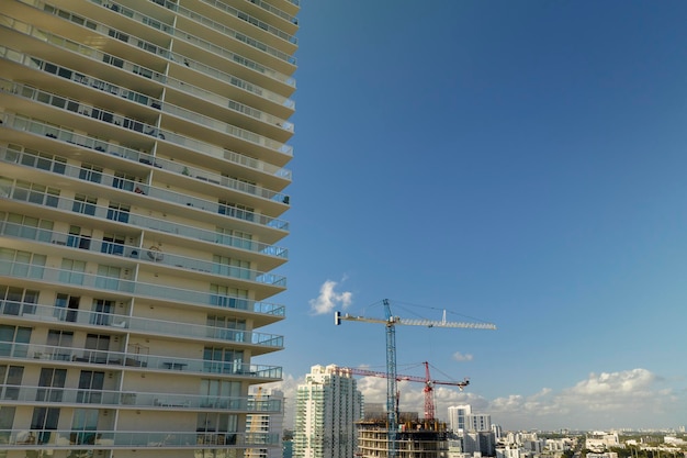 Vista aérea del nuevo residencial en desarrollo en el área urbana estadounidense Grúas torre en el sitio de construcción industrial en Miami Florida Concepto de crecimiento de la vivienda en los Estados Unidos