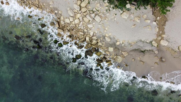 Vista aérea de las olas del mar y la costa rocosa de fantásticos acantilados