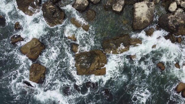 Vista aérea de las olas del mar y la costa rocosa de fantásticos acantilados