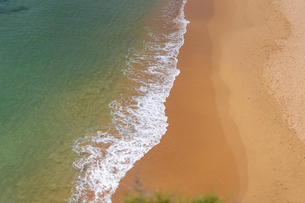 Vista aérea de las olas del mar y la playa de arena