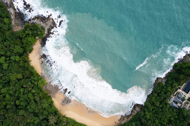 Vista aérea de las olas del mar rompiendo olas blancas que hacen espuma en las rocas de la orilla del mar Vista superior Costa rocosa