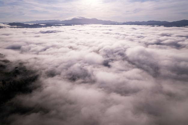 Vista aérea de ondas de niebla que fluyen en la selva tropical de montañaImagen de vista de pájaro sobre las nubes Increíble fondo de naturaleza con nubes y picos de montaña en Tailandia