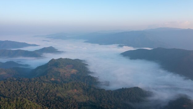 Vista aérea del paisaje niebla y niebla en el valle y la luz del sol en la escena de la mañana