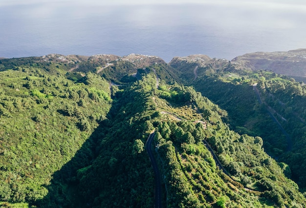 Vista aérea del paisaje salvaje de bosques y montañas con caminos cerca de la costa