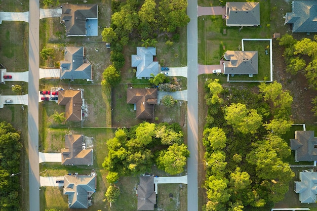 Vista aérea del paisaje suburbano con casas privadas entre palmeras verdes en la tranquila zona residencial de Florida