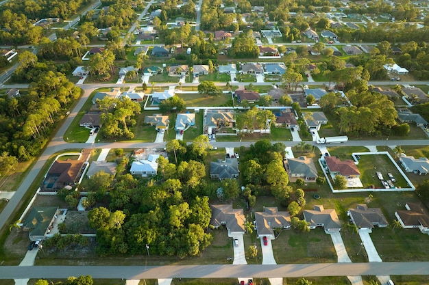 Vista aérea del paisaje suburbano con casas privadas entre palmeras verdes en la tranquila zona residencial de Florida