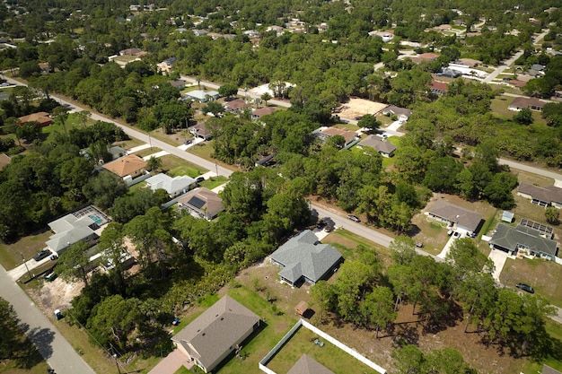 Vista aérea del paisaje suburbano de la pequeña ciudad de América con casas privadas entre palmeras verdes en la tranquila zona residencial de Florida