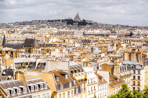 Foto vista aérea del paisaje urbano en el hermoso horizonte con la colina de monmartre durante el tiempo nublado en parís