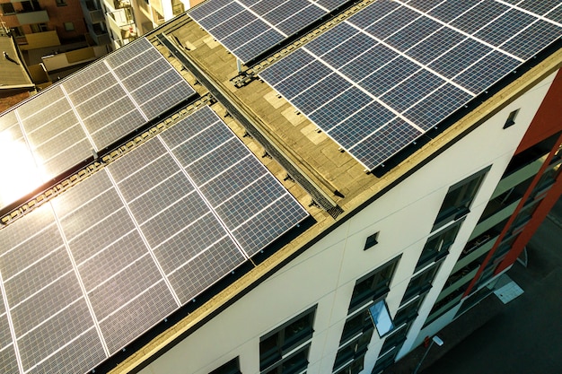 Vista aérea de paneles solares fotovoltaicos en una azotea del bloque de construcción residencial para producir energía eléctrica limpia. Concepto de vivienda autónoma.