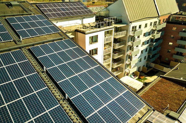 Vista aérea de paneles solares fotovoltaicos en una azotea del bloque de construcción residencial para producir energía eléctrica limpia. Concepto de vivienda autónoma.