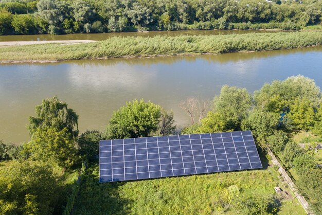 Vista aérea de paneles solares fotovoltaicos azules montados en el suelo del patio trasero para producir electricidad ecológica limpia Concepto de producción de energía renovable
