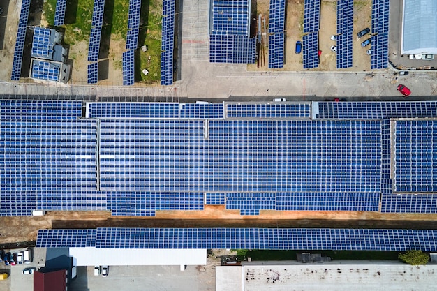 Vista aérea de paneles solares fotovoltaicos azules montados en el techo de un edificio industrial para producir electricidad ecológica verde. Producción de concepto de energía sostenible.