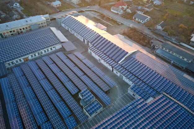Vista aérea de paneles solares fotovoltaicos azules montados en el techo de un edificio industrial para producir electricidad ecológica verde Producción del concepto de energía sostenible