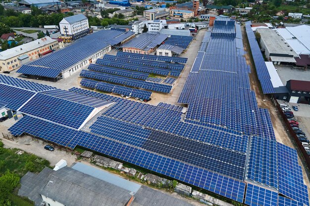 Vista aérea de paneles solares fotovoltaicos azules montados en el techo de un edificio industrial para producir electricidad ecológica verde Producción del concepto de energía sostenible