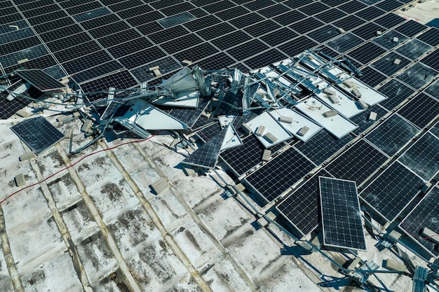 Vista aérea de los paneles solares fotovoltaicos dañados por el viento del huracán montados en el techo de un edificio industrial para producir electricidad ecológica verde Consecuencias de un desastre natural