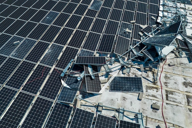 Vista aérea de los paneles solares fotovoltaicos dañados por el viento del huracán montados en el techo de un edificio industrial para producir electricidad ecológica verde Consecuencias de los desastres naturales