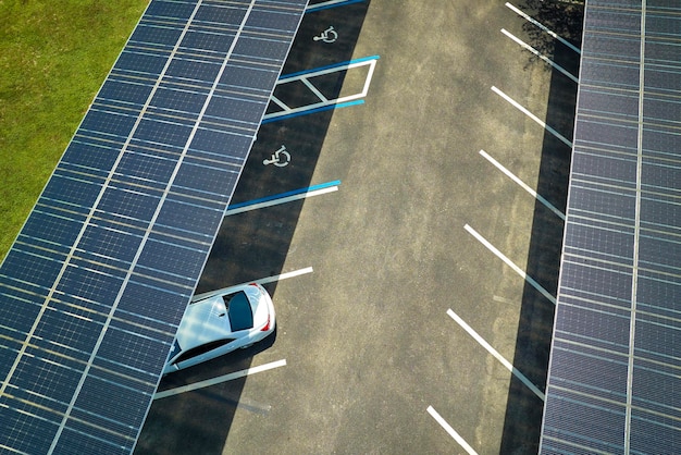 Vista aérea de paneles solares instalados como techo de sombra sobre estacionamiento para autos estacionados para la generación efectiva de electricidad limpia Tecnología fotovoltaica integrada en infraestructura urbana