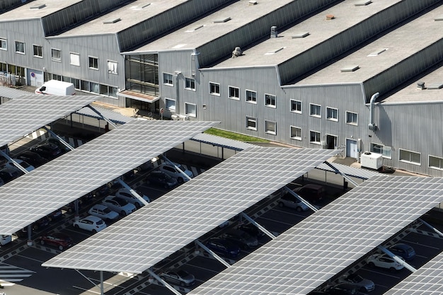 Vista aérea de paneles solares instalados como techo de sombra sobre estacionamiento con autos estacionados para la generación efectiva de electricidad limpia Tecnología fotovoltaica integrada en infraestructura urbana