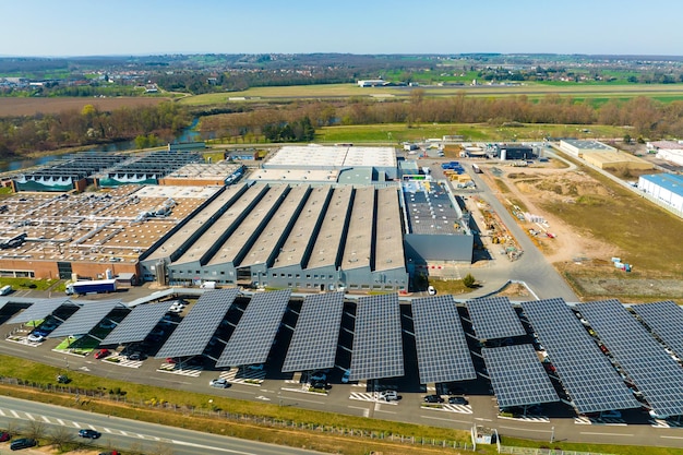 Vista aérea de paneles solares instalados como techo de sombra sobre estacionamiento con autos estacionados para la generación efectiva de electricidad limpia Tecnología fotovoltaica integrada en infraestructura urbana