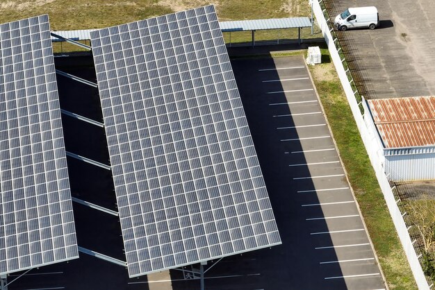 Vista aérea de paneles solares instalados sobre un estacionamiento con autos estacionados para la generación efectiva de energía limpia