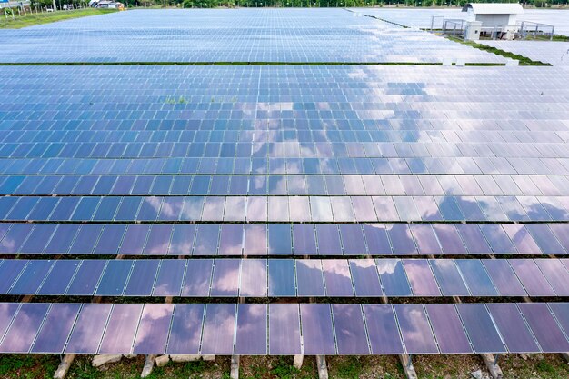 Vista aérea de paneles solares o células solares en el techo de la granja. Planta de energía con campo verde, fuente de energía renovable en Tailandia