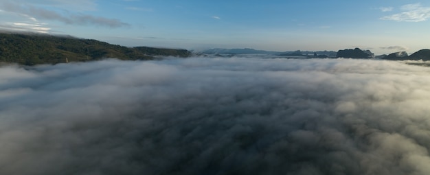 Vista aérea panorama das ondas de nevoeiro fluindo na floresta tropical da montanhaimagem da vista do pássaro sobre o