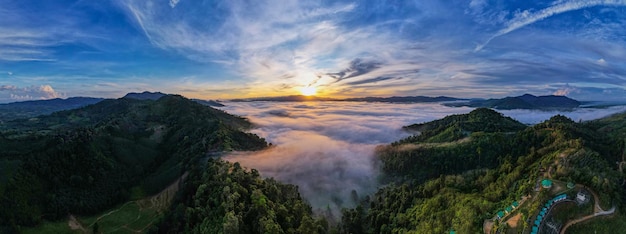 Vista aérea Panorama de ondas de niebla que fluyen en la selva tropical de montañaImagen de vista de pájaro sobre las nubes Increíble fondo de naturaleza con nubes y picos de montaña en Tailandia