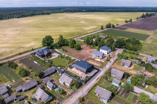 Vista aérea panorámica de la aldea ecológica con casas de madera, jardines y huertos de grava