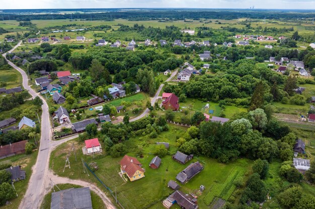 Vista aérea panorámica de la aldea ecológica con casas de madera, jardines y huertos de grava