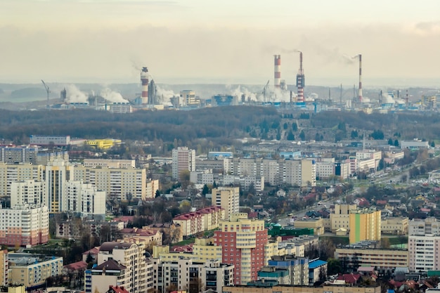 Vista aérea panorâmica da fumaça dos cachimbos como pano de fundo de um enorme complexo residencial com arranha-céus e setor privado Conceito de poluição do ar e da água