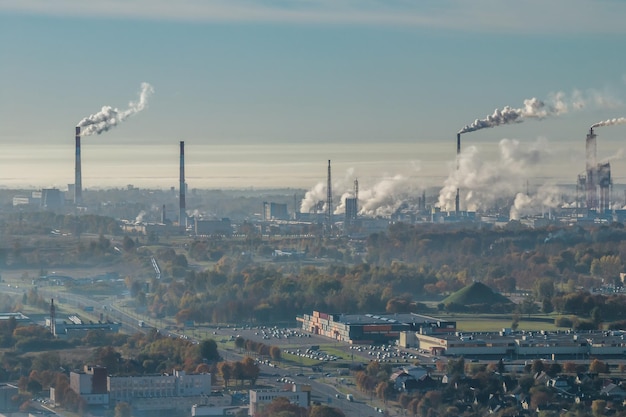 Vista aérea panorámica del humo de las tuberías como fondo de un enorme complejo residencial con edificios de gran altura y sector privado Concepto de contaminación del aire y el agua