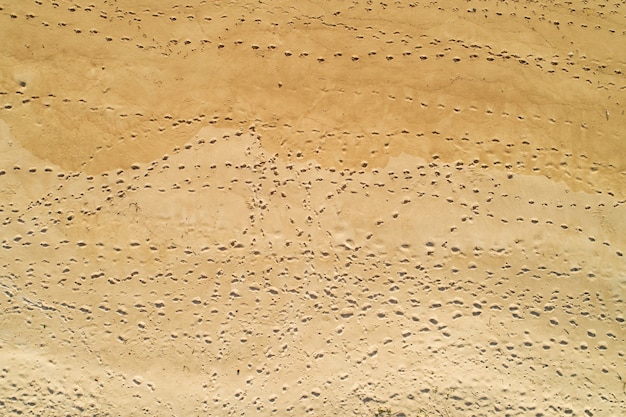 Vista aérea pegadas na areia na praia fundo de textura de areia de natureza incrível.