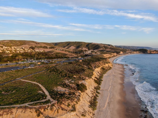 Vista aérea de la pequeña carretera de Newport Beach junto al acantilado durante el crepúsculo del atardecer