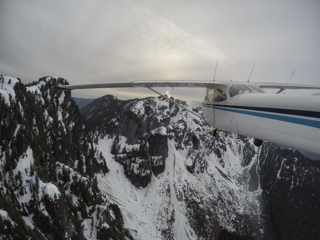 Vista aérea de un pequeño avión que vuela sobre el paisaje montañoso canadiense