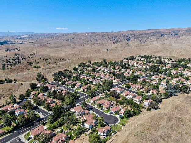 Vista aérea de un pequeño barrio con una montaña desértica seca al fondo en Moorpark California