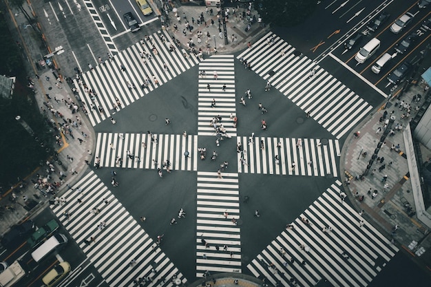 Vista aérea de personas caminando por el cruce peatonal de la ciudad