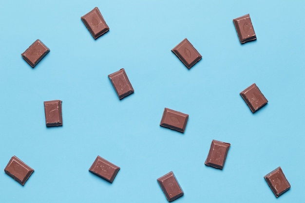 Foto una vista aérea de piezas de chocolate sobre fondo azul