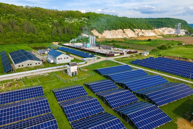 Vista aérea de la planta de energía eléctrica con filas de paneles solares fotovoltaicos para producir energía eléctrica ecológica limpia en el área industrial. Electricidad renovable con concepto de emisión cero.