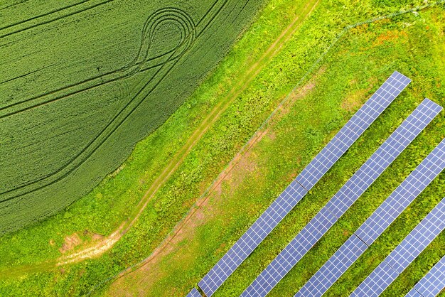 Vista aérea de la planta de energía solar en campo verde. Cuadros eléctricos para producir energía ecológica limpia.