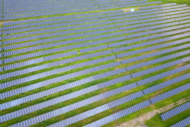 Vista aérea de la planta de energía solar en campo verde. Cuadros eléctricos para producir energía ecológica limpia.