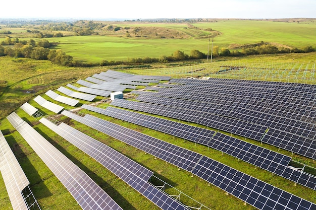 Vista aérea de la planta de energía solar en construcción en campo verde. Montaje de cuadros eléctricos para producción de energía ecológica limpia.