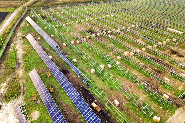 Vista aérea de la planta de energía solar en construcción en campo verde.