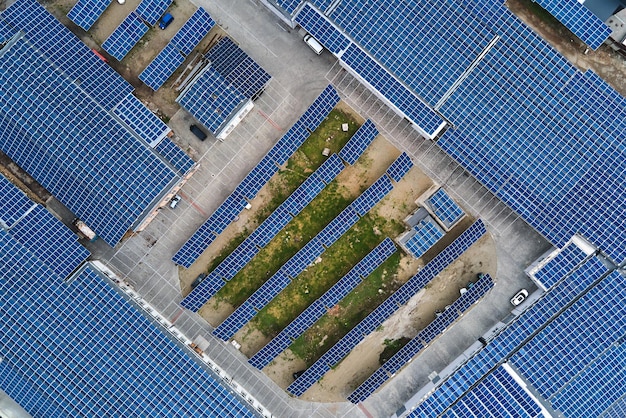 Vista aérea de la planta de energía solar con paneles fotovoltaicos azules montados en el techo de un edificio industrial para producir electricidad ecológica verde Producción del concepto de energía sostenible