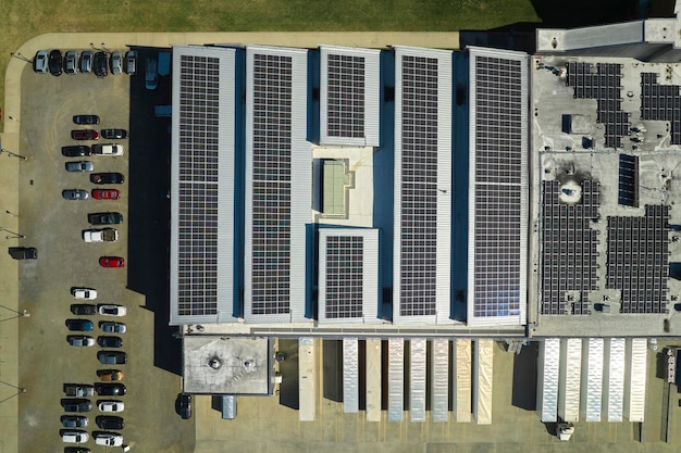 Vista aérea de la planta de energía solar con paneles fotovoltaicos azules montados en el techo de un edificio industrial para producir electricidad ecológica verde producción del concepto de energía sostenible