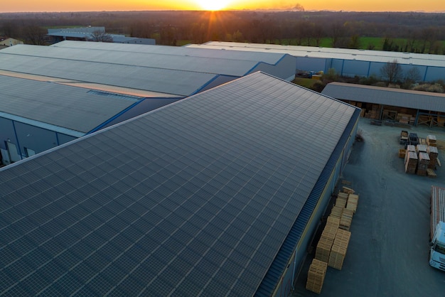 Vista aérea de la planta de energía solar con paneles fotovoltaicos azules montados en el techo de un edificio industrial para producir electricidad ecológica verde Producción del concepto de energía sostenible